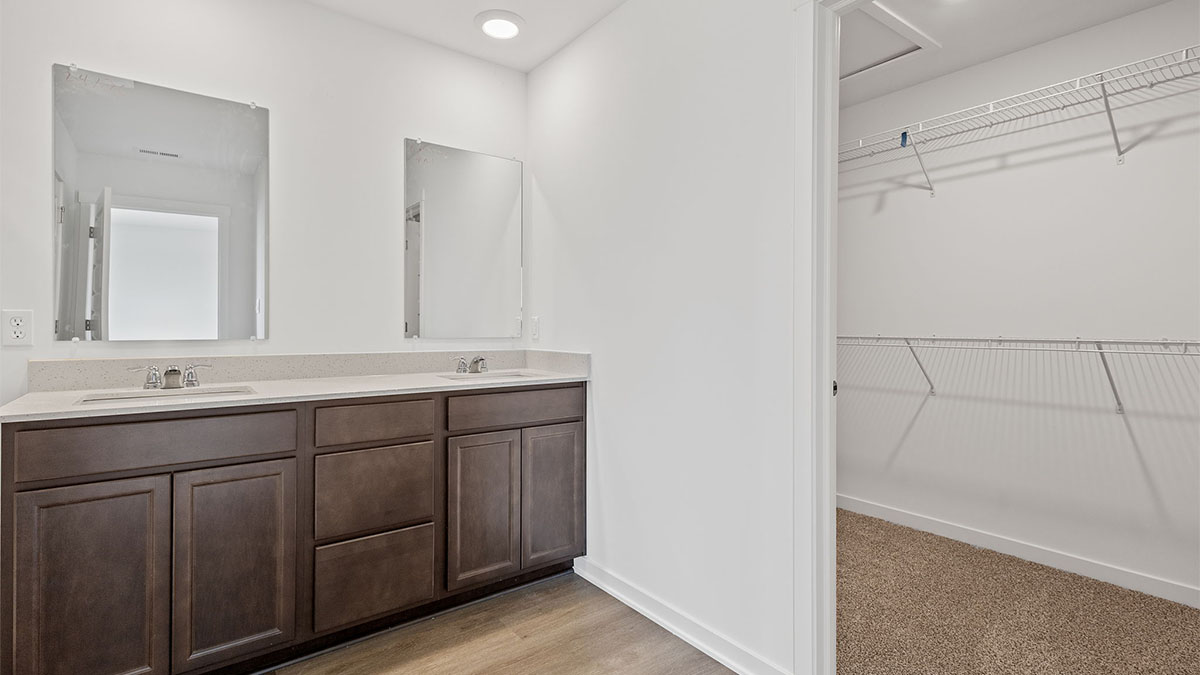 Dual vanity sink with a walk in closet.