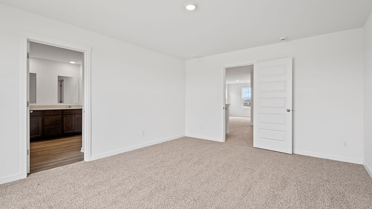 Bedroom with carpet and a bathroom.