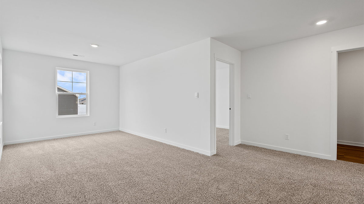 Loft room with carpet and a window.