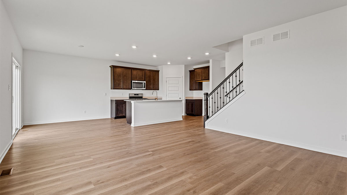 Living area with hard wood floors and a view of kitchen.
