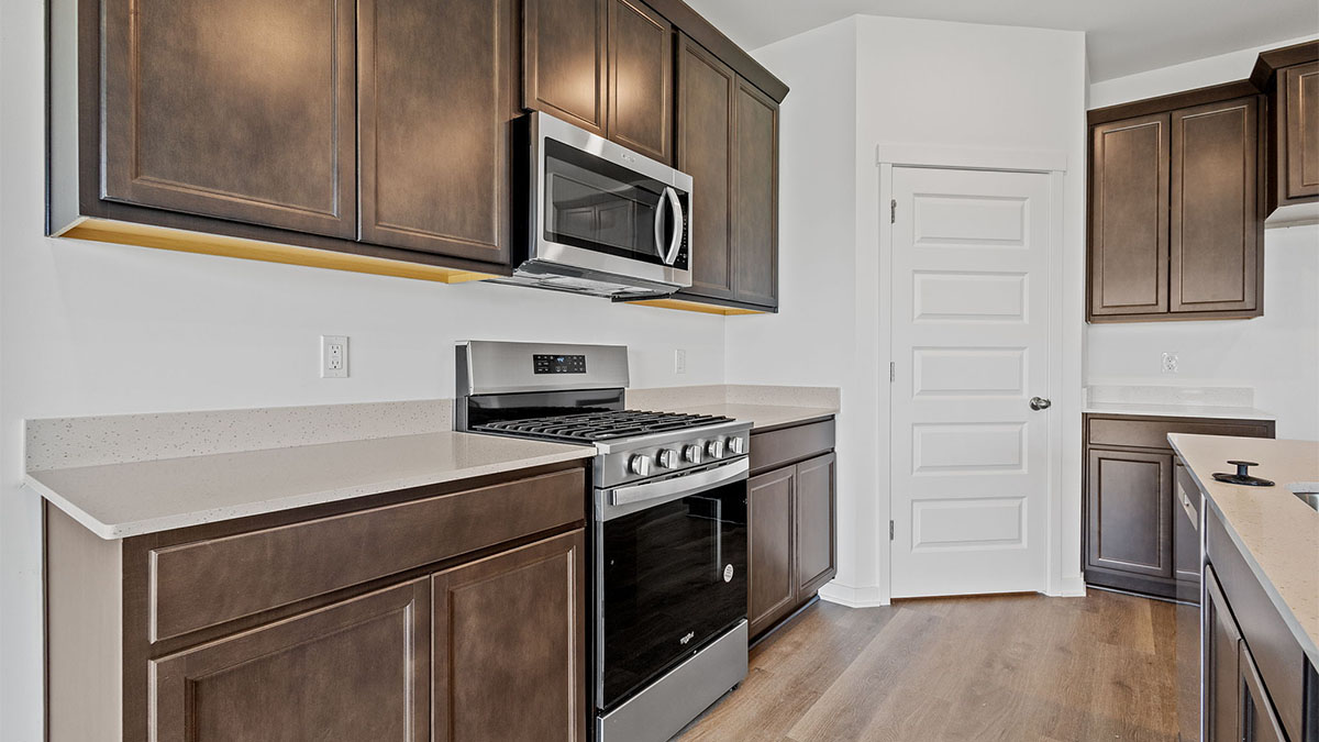 Kitchen with brown cabinets and microwave.