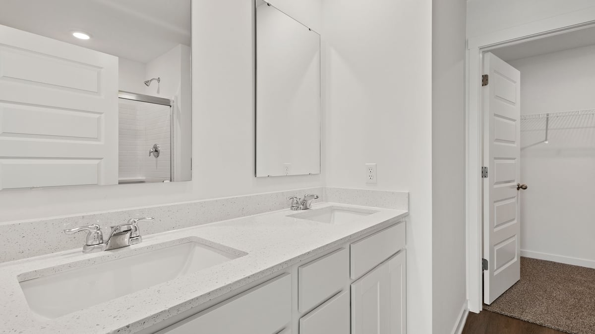 Dual vanity sink with a walk in shower and closet.