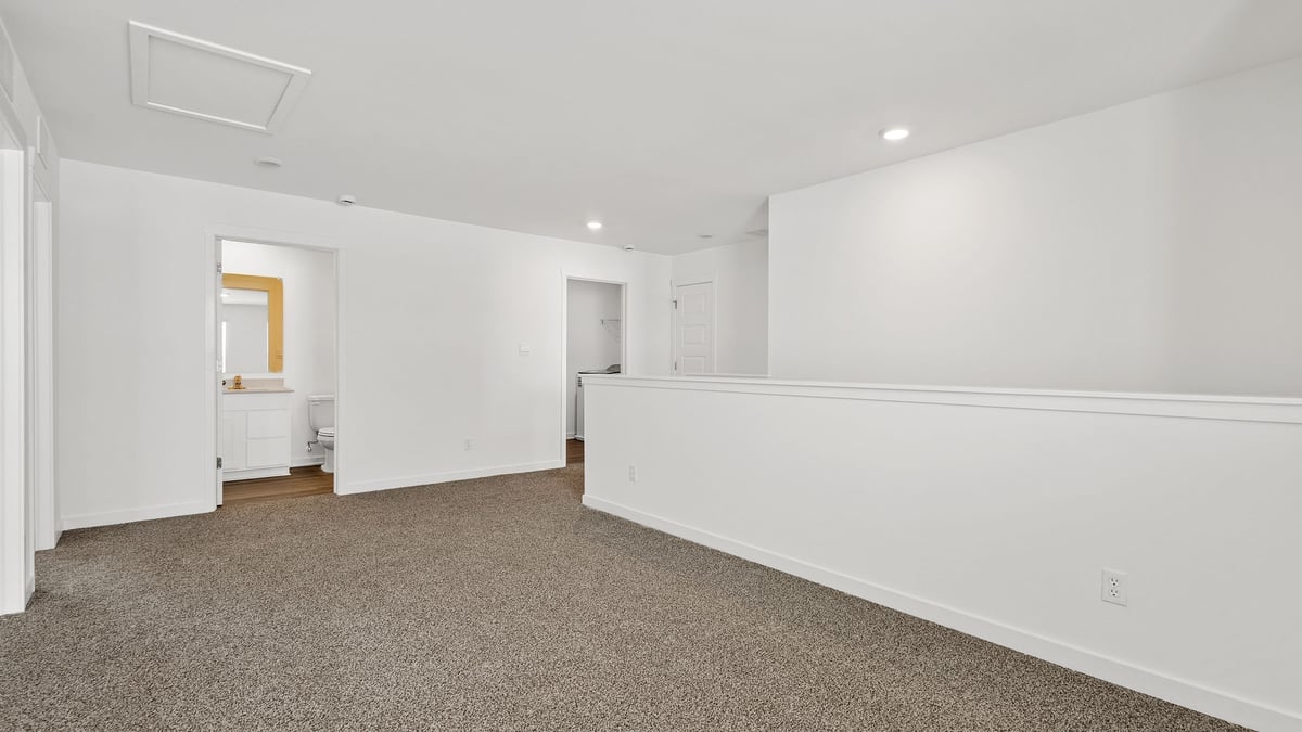 Upstairs loft area with carpeted floors.