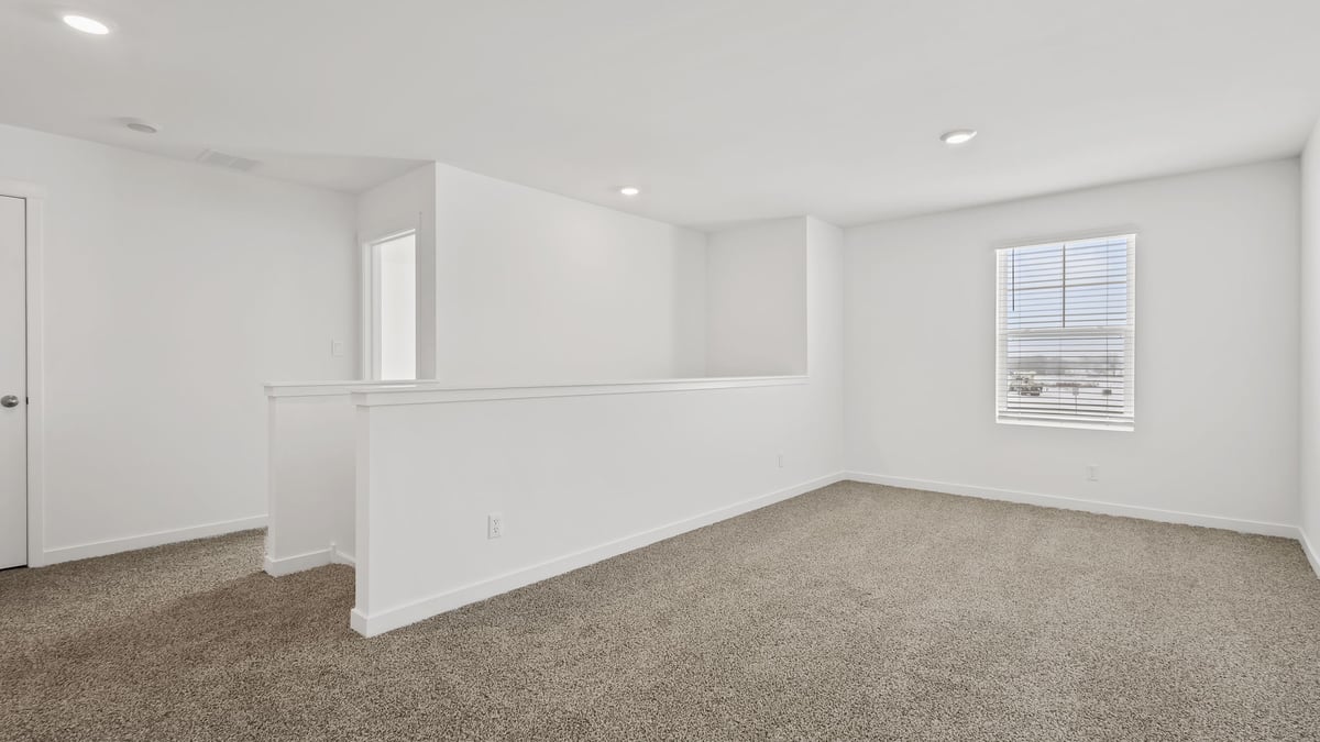Loft area with carpeted floors with a window.