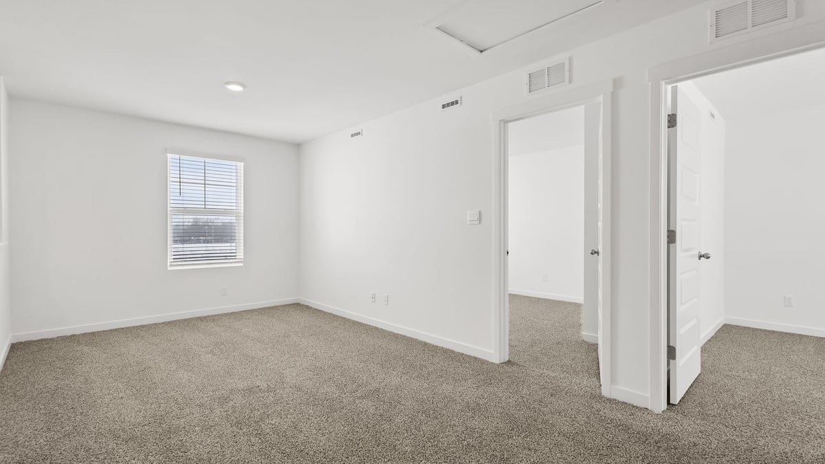 Loft area with carpeted floors with a side window.