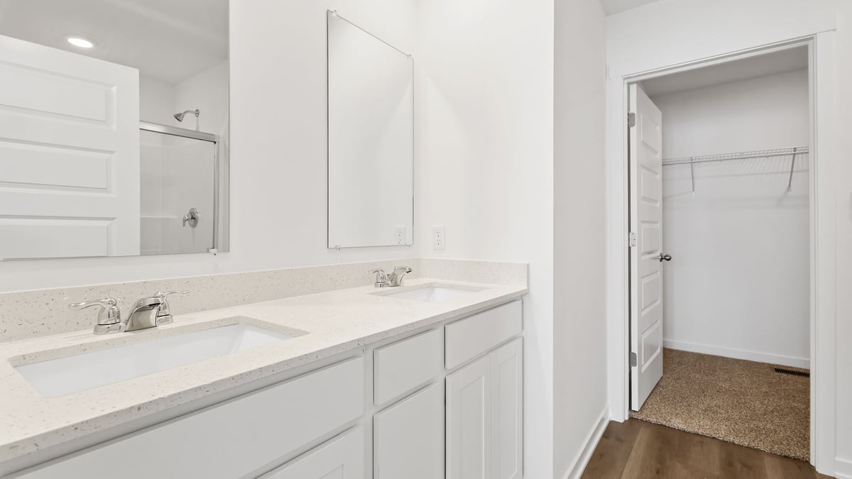 Dual vanity sinks with a walk-in closet.
