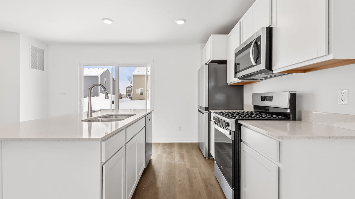 Kitchen with white cabinets and quartz countertops.