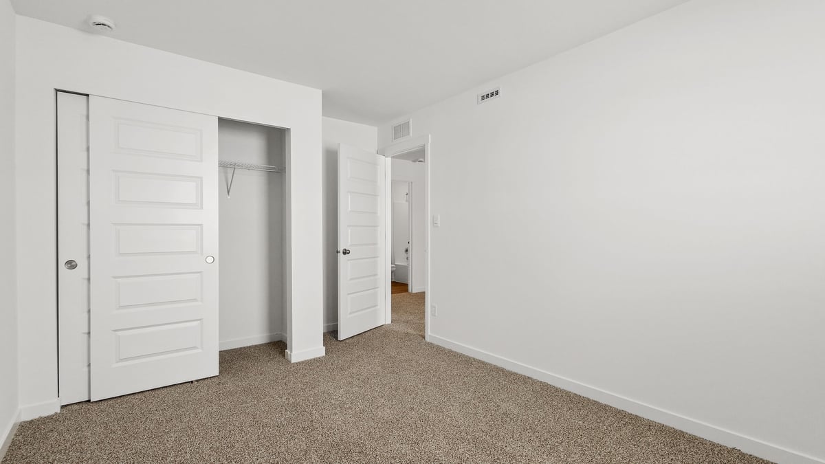 Bedroom with carpet and a closet.