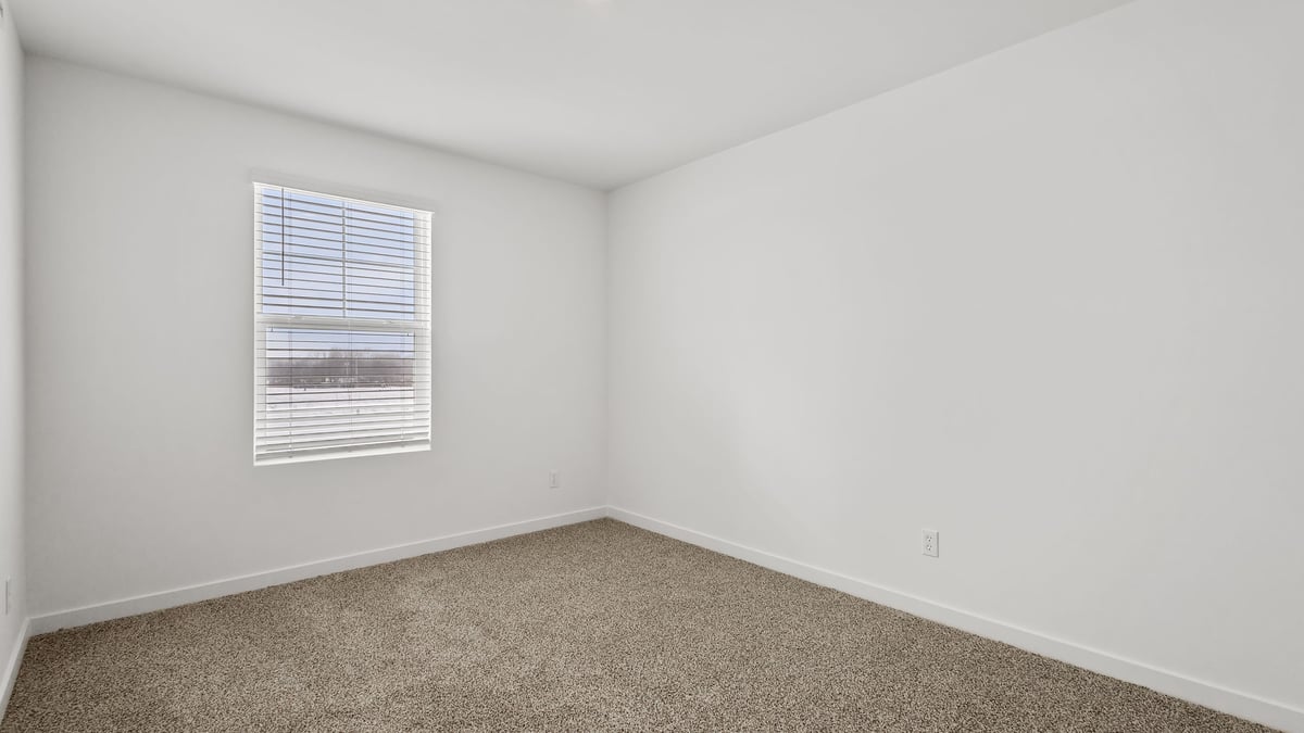 Bedroom with a window and carpeted floors.