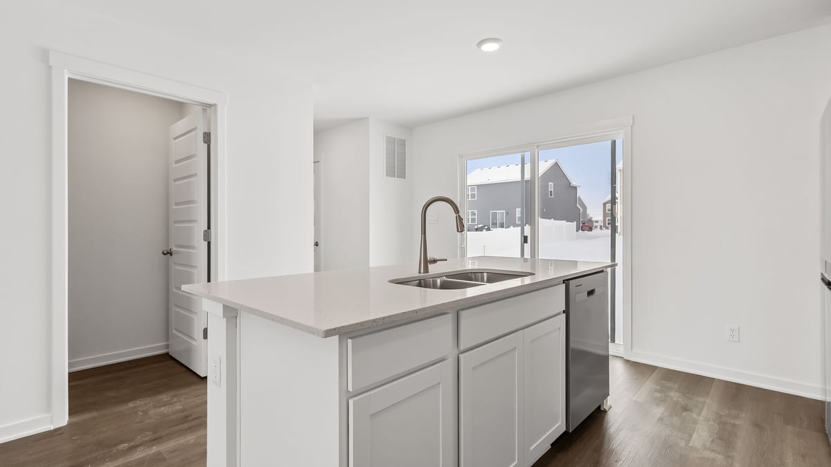 Kitchen island with quartz countertops and hard wood floors.