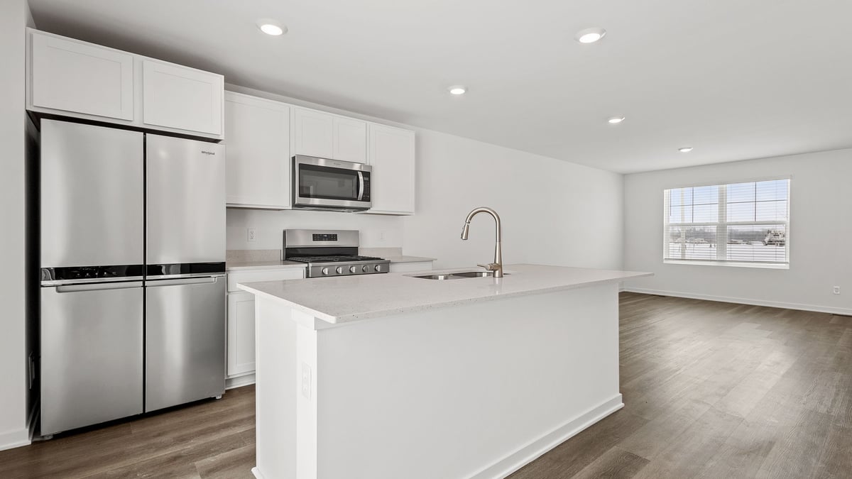 Kitchen with white cabinets with quartz countertops.
