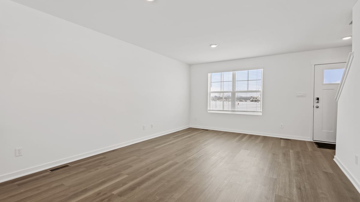 Open concept layout with hard wood floors and a big window.