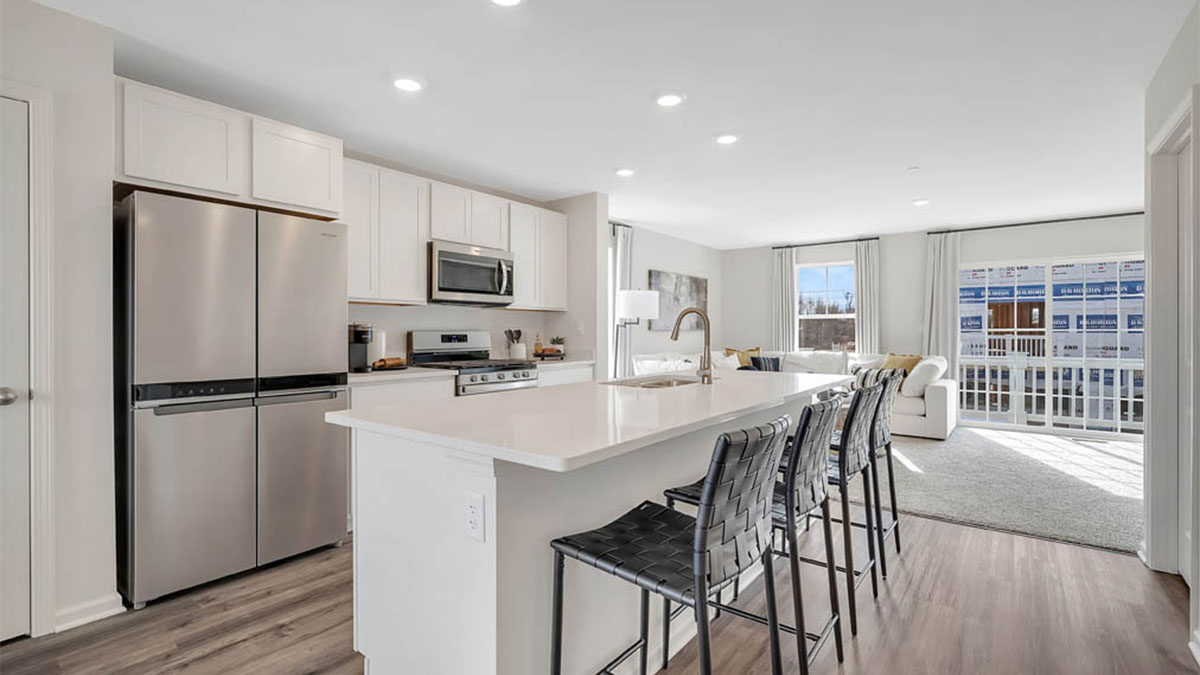 Kitchen with white cabinets with hard wood floors with a kitchen island.