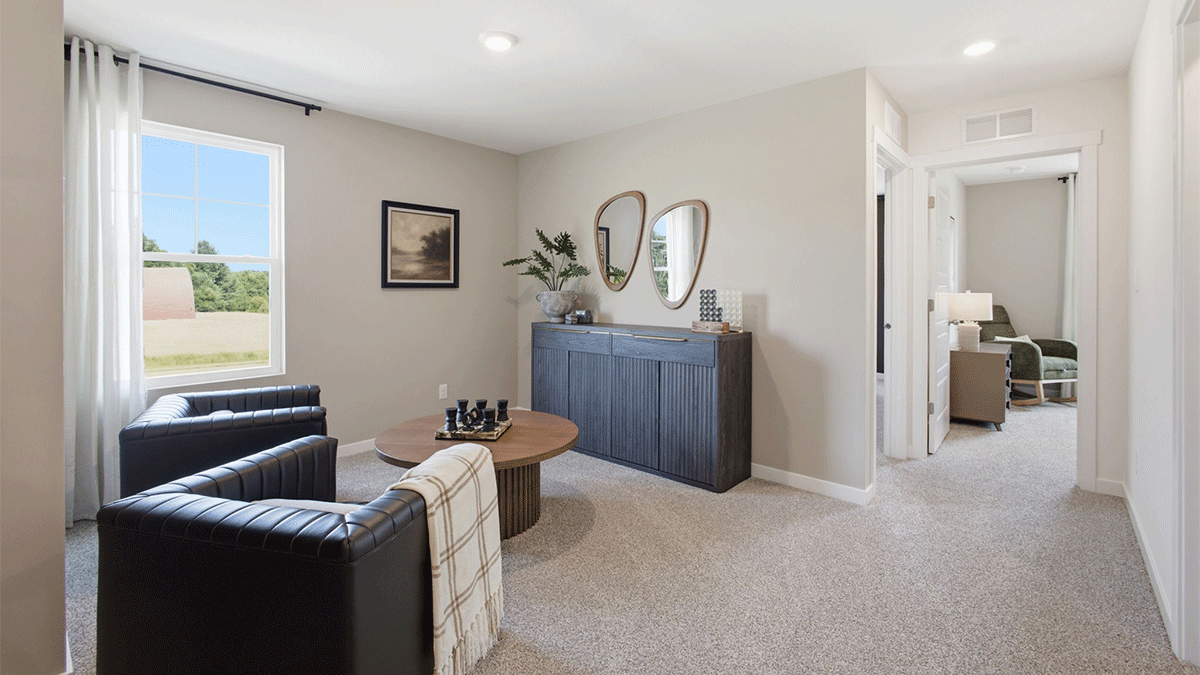 Loft area with carpeted floors with a side window.