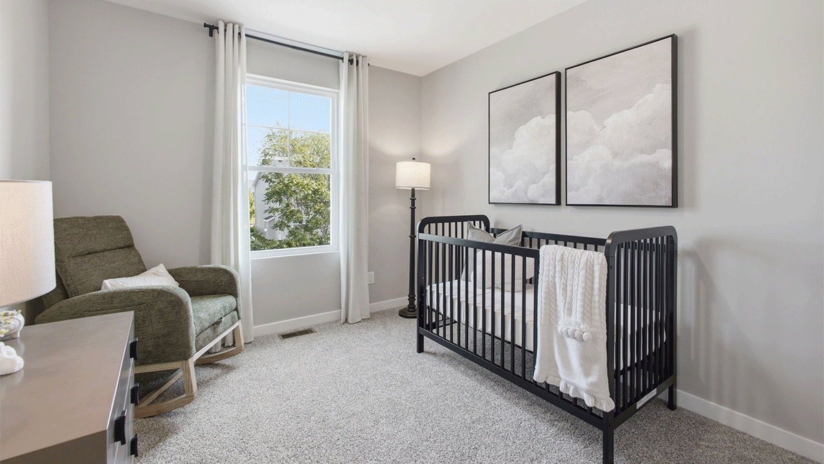 Bedroom staged as a nursery and a side window.