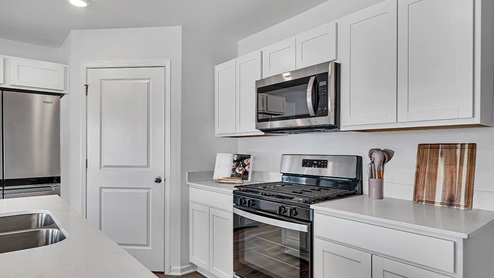 kitchen with white cabinetry, large island, and stainless steel appliances