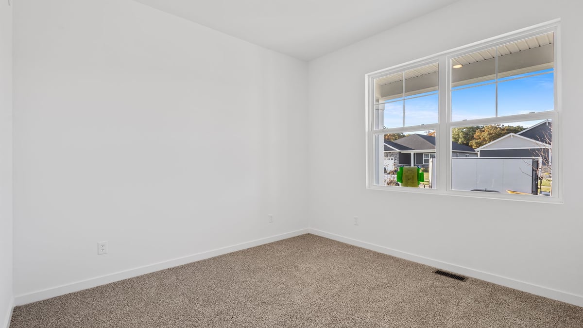 Bedroom with carpet and a big window.