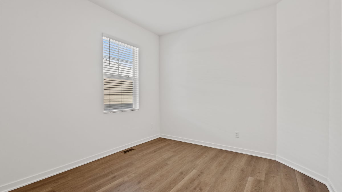 Bedroom with a hard wood floors and a window.