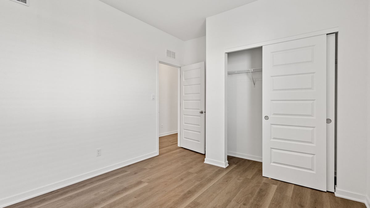 Bedroom with hard wood flooring and a closet