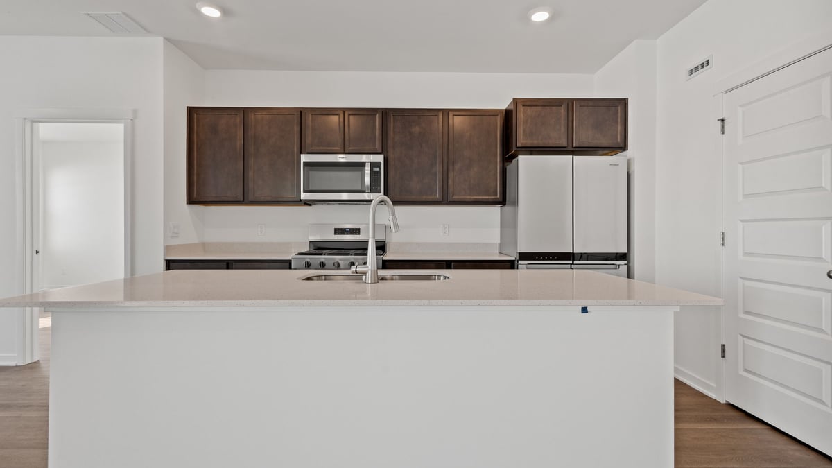 Kitchen with dark cabinets and hard wood floors.