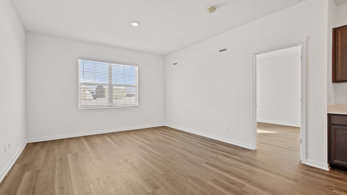 Room with a big window and a hard wood floors.