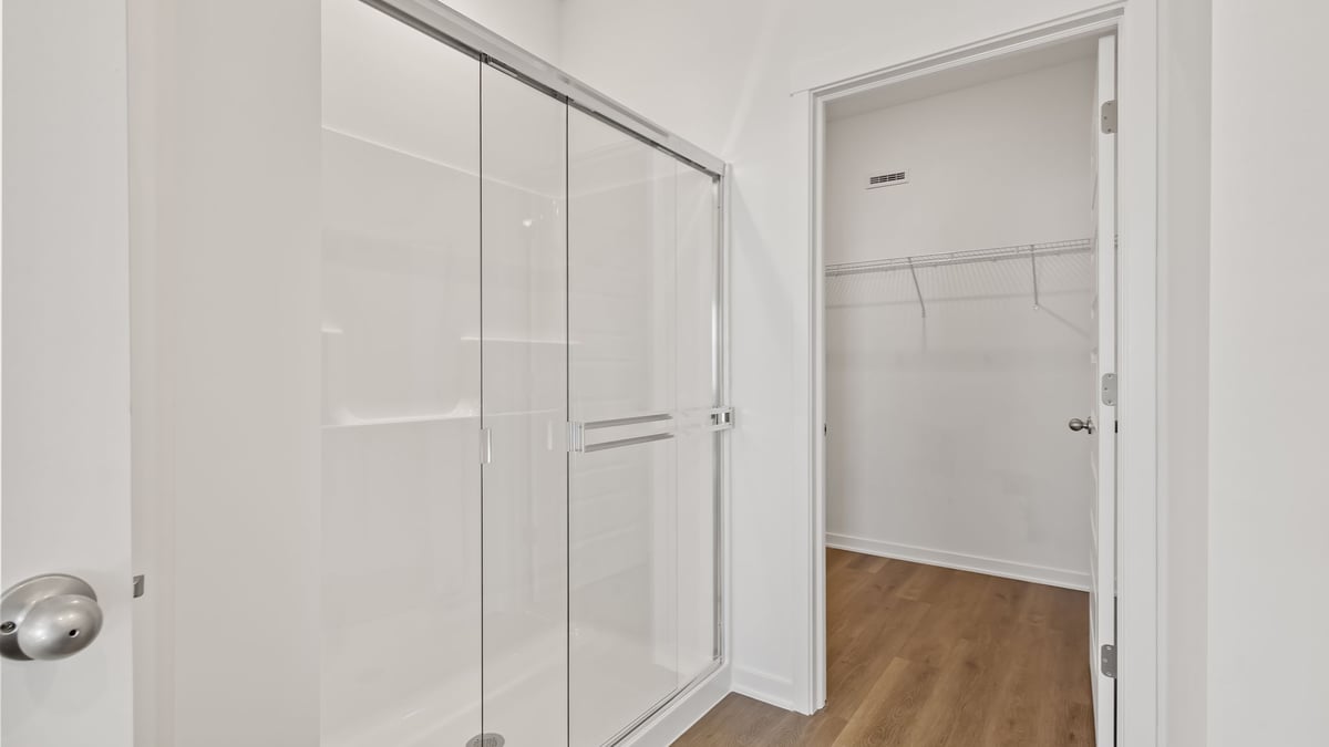 Bathroom with a walk in shower and a walk in closet.