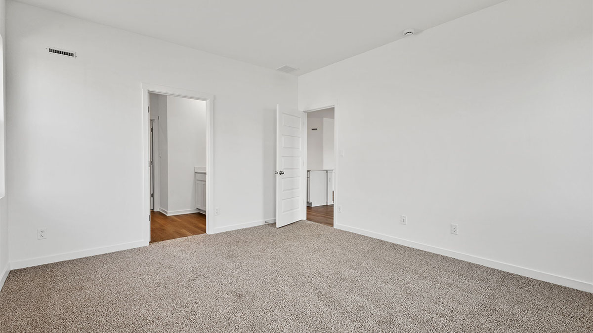 Bedroom with carpet and a bathroom and closet.