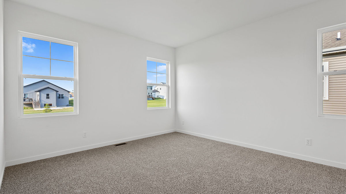 Bedroom with carpet and two windows.
