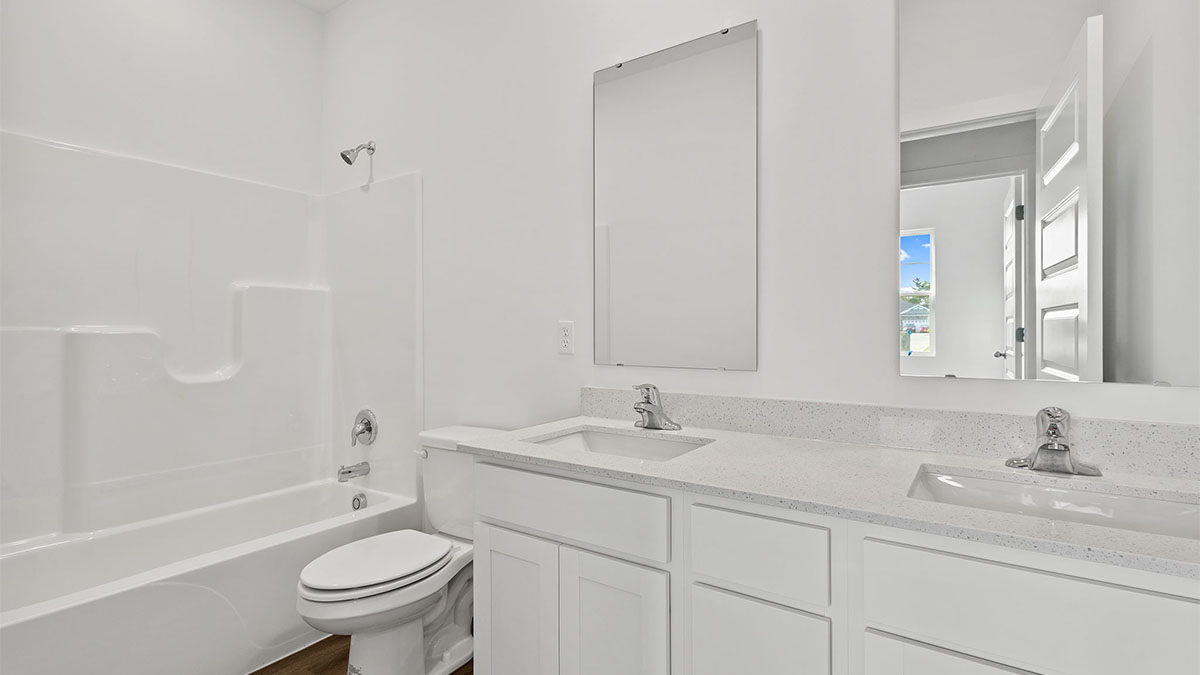 Bathroom with dual vanity sinks and a shower.