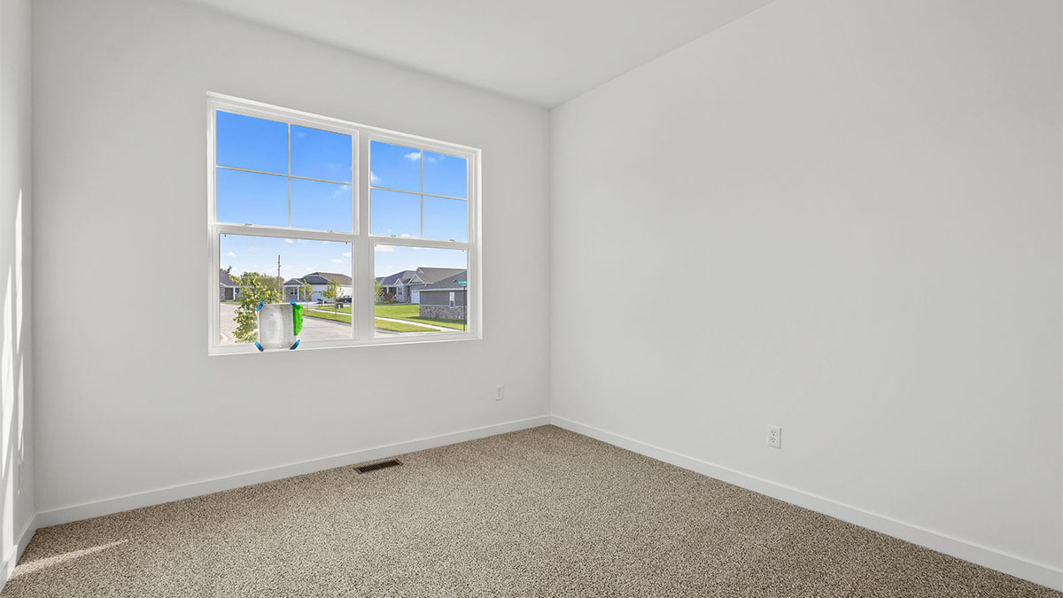 Bedroom with carpet and a big window.