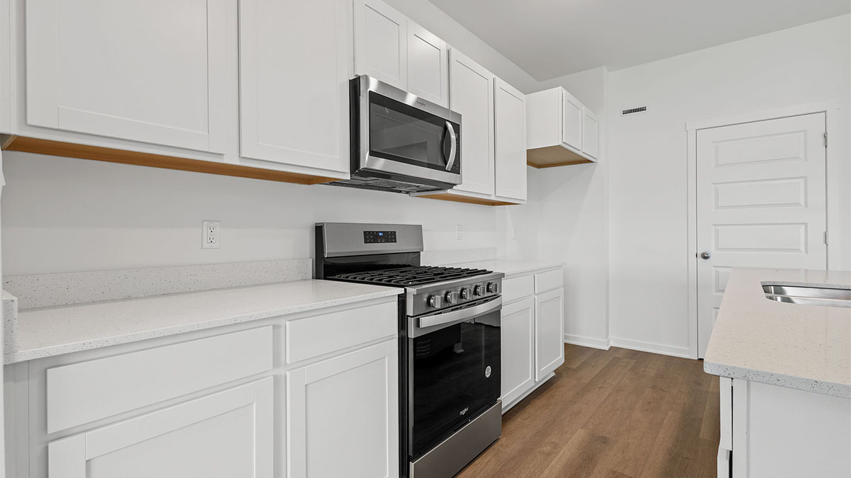 Kitchen with white cabinets and a microwave.