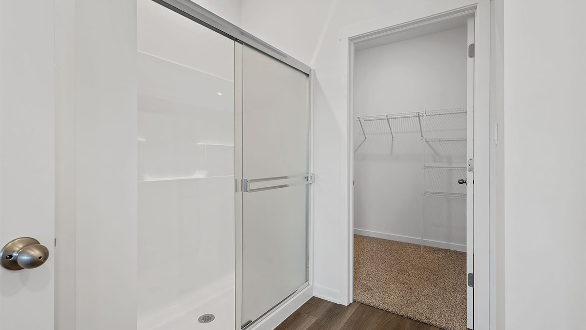 Bathroom with a walk in shower and a walk in closet.