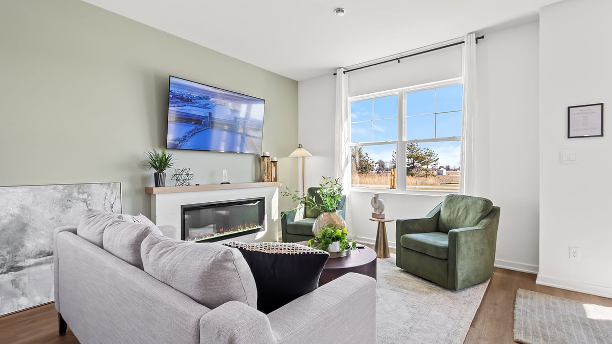 Living room area with hard wood flooring and a big window.
