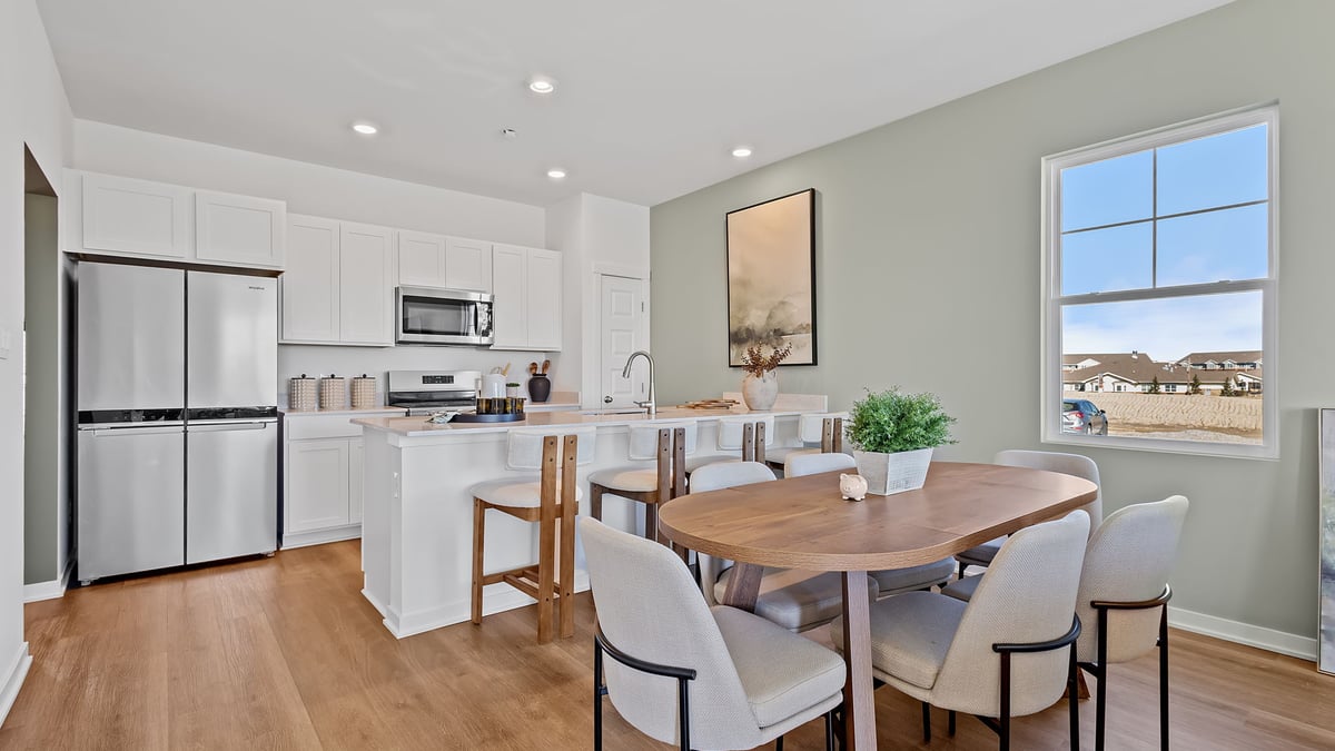 Kitchen and dining area with hard wood flooring and a side window.