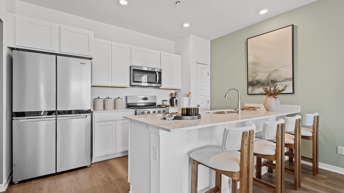 Kitchen with whtie cabinetry and quartz countertops.