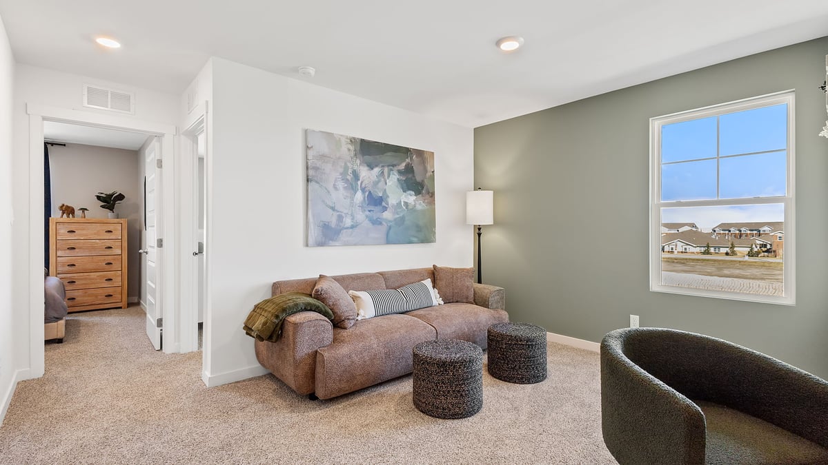 Upstairs loft area with a side window and carpeted floors.