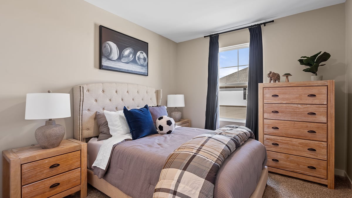 Bedroom staged as a kids sports room with a side window.