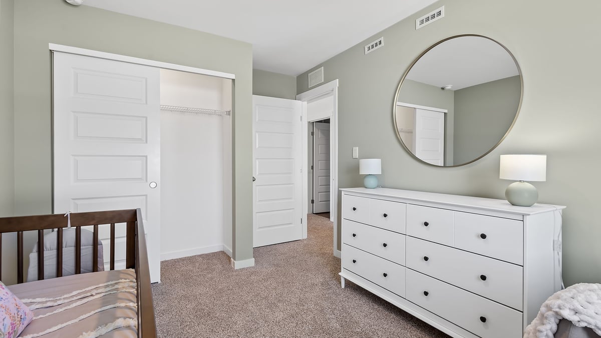 Bedroom staged as nursery with a closet.