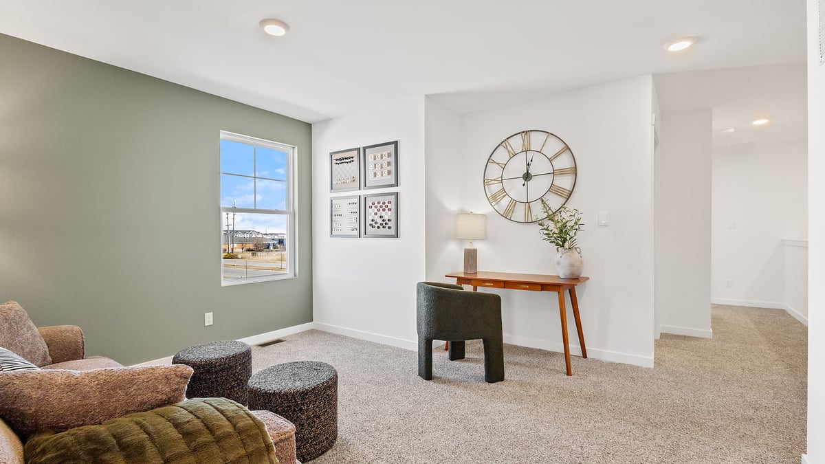 Loft area with carpet and couch with a side desk.