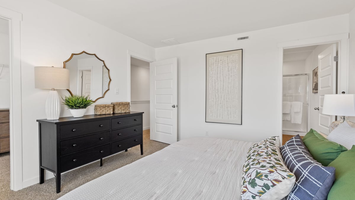 Primary bedroom with carpeted floors and own bathroom suite.