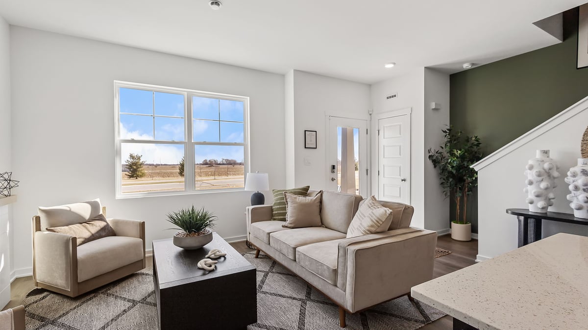 Living room with a big window and hard wood floors.
