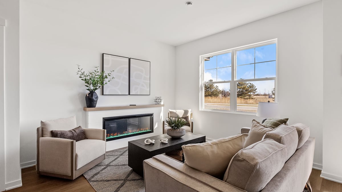 Living room area with a big window and hard wood floors.