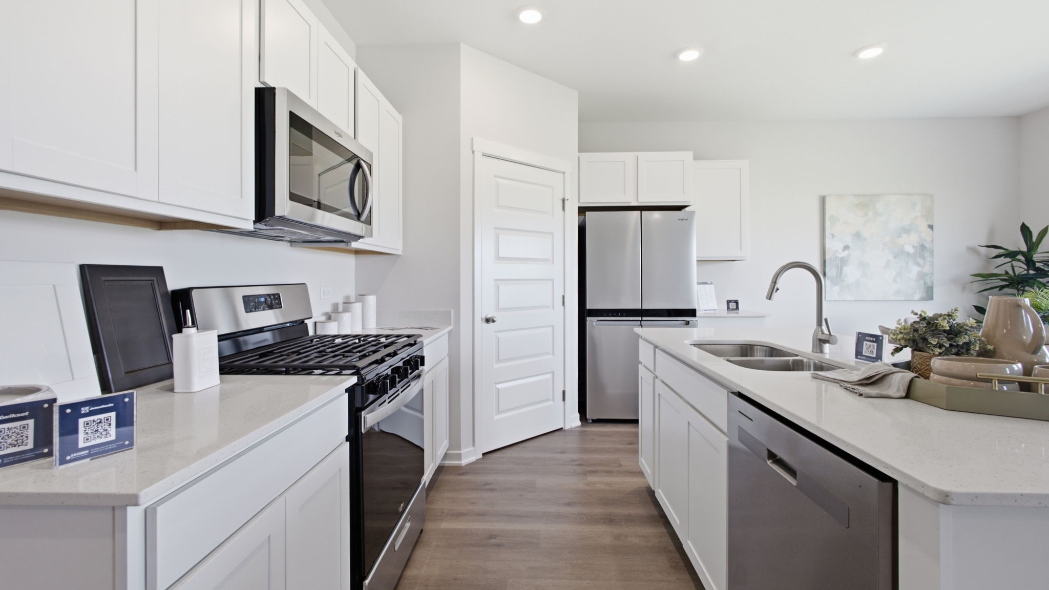 Kitchen with white cabinetry and quartz countertops.