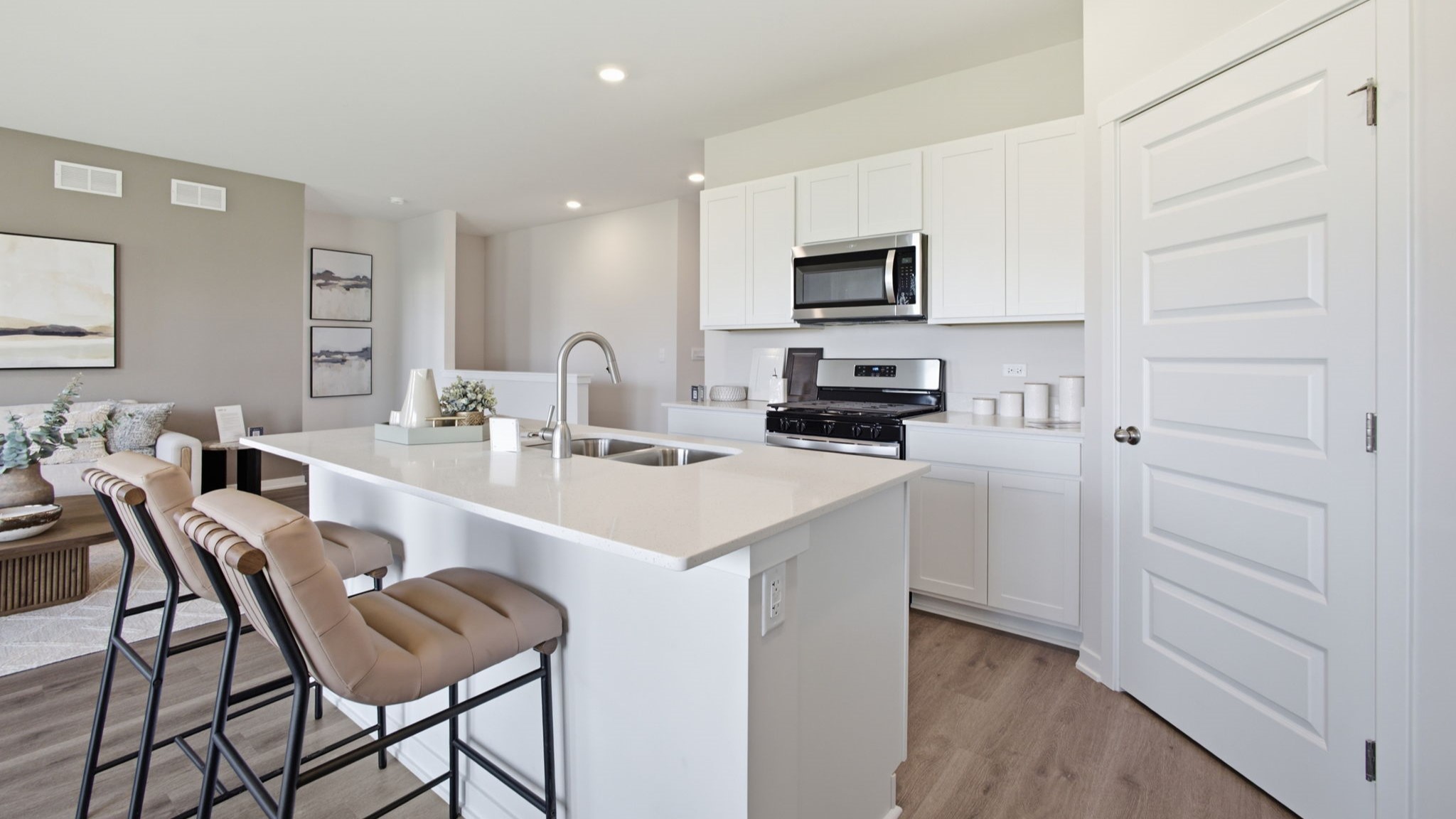 Kitchen with white cabinetry and hardwood floors.