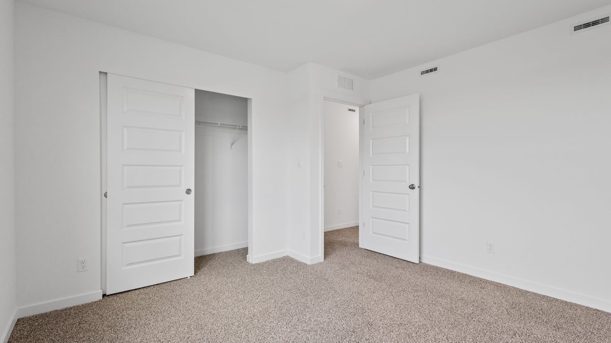 Bedroom with carpeted floors and a closet.