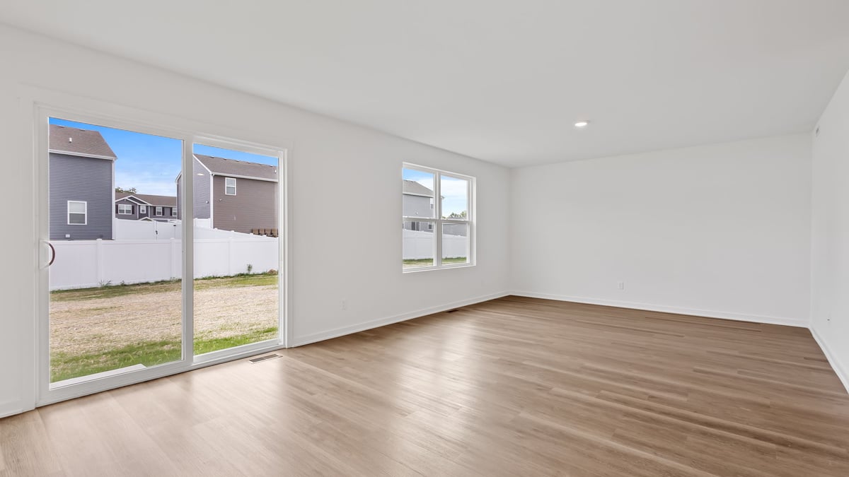 Dining and living room area with great space and hard wood floors with a glass sliding door.
