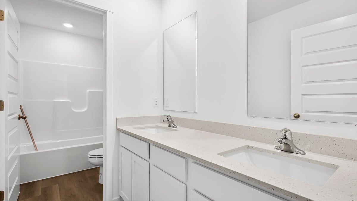 Primary bathroom with a dual vanity sink and a walk-in closet.