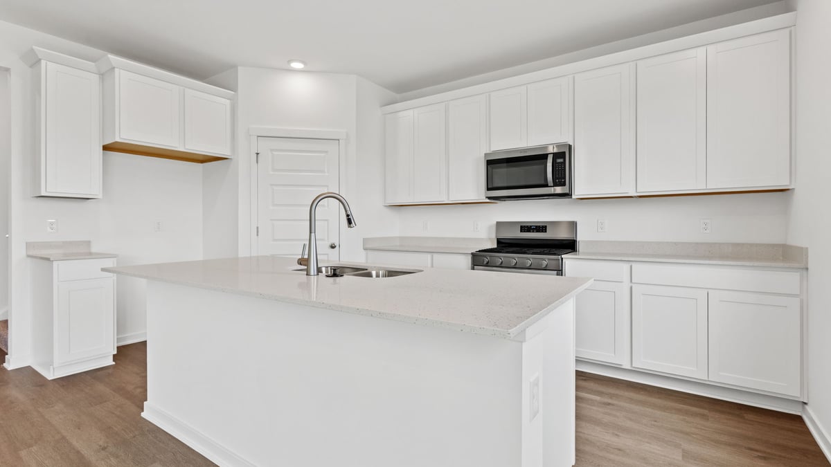 Kitchen of white cabinets with quartz countertops.