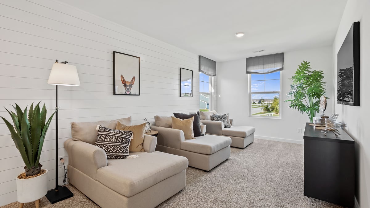 Loft room with carpet and a side window as a sitting area.