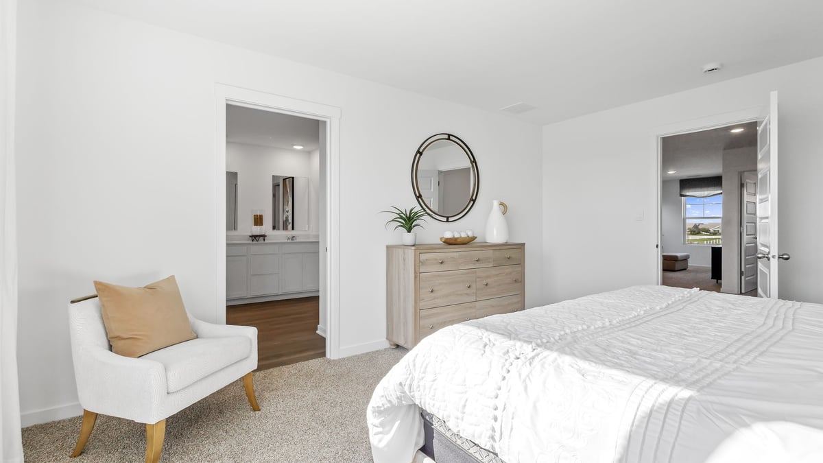 Primary bedroom with carpeted floors and own bathroom suite.